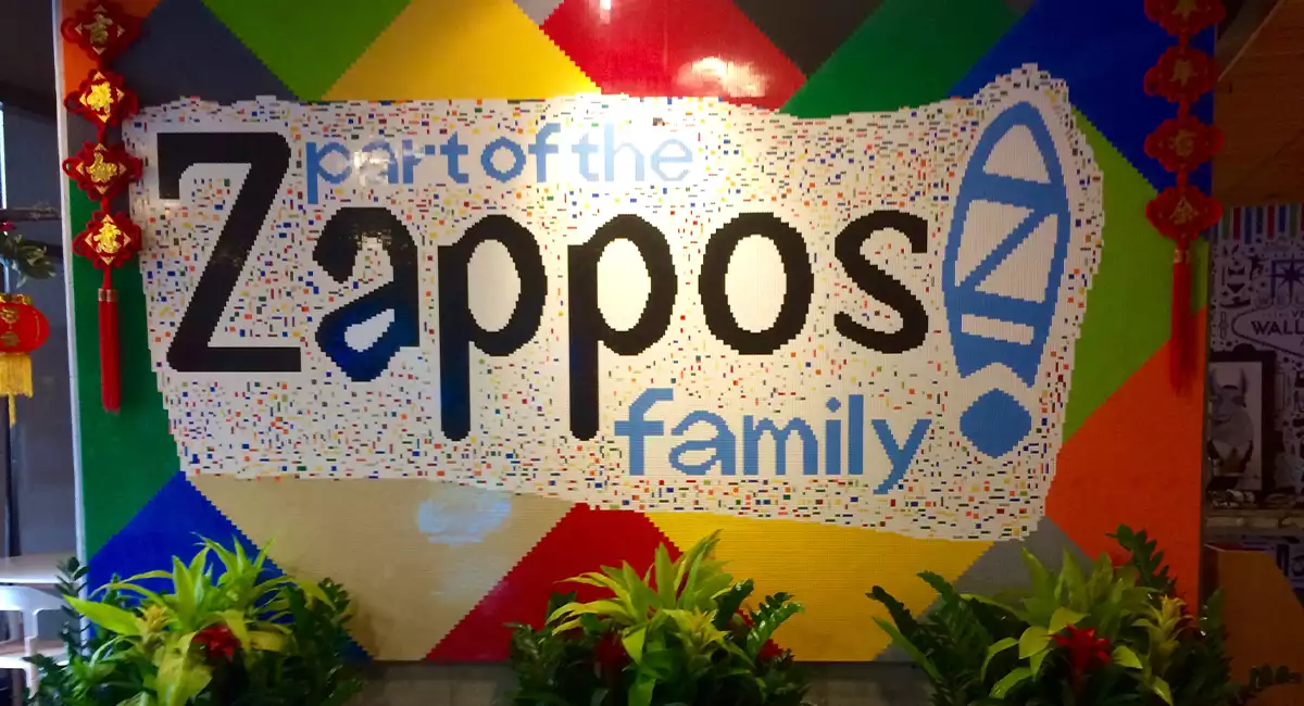 Live plants under Zappos sign that says, Part of the Zappos family