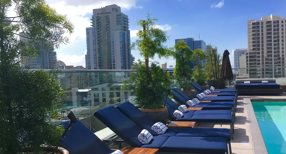 Outdoor rooftop pool seating area with live plants