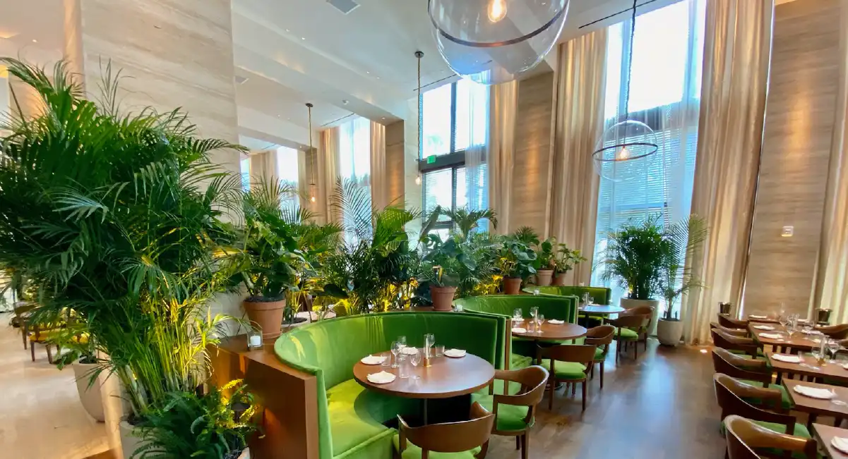 Restaurant dining area enhanced with lush indoor plants and natural design elements.