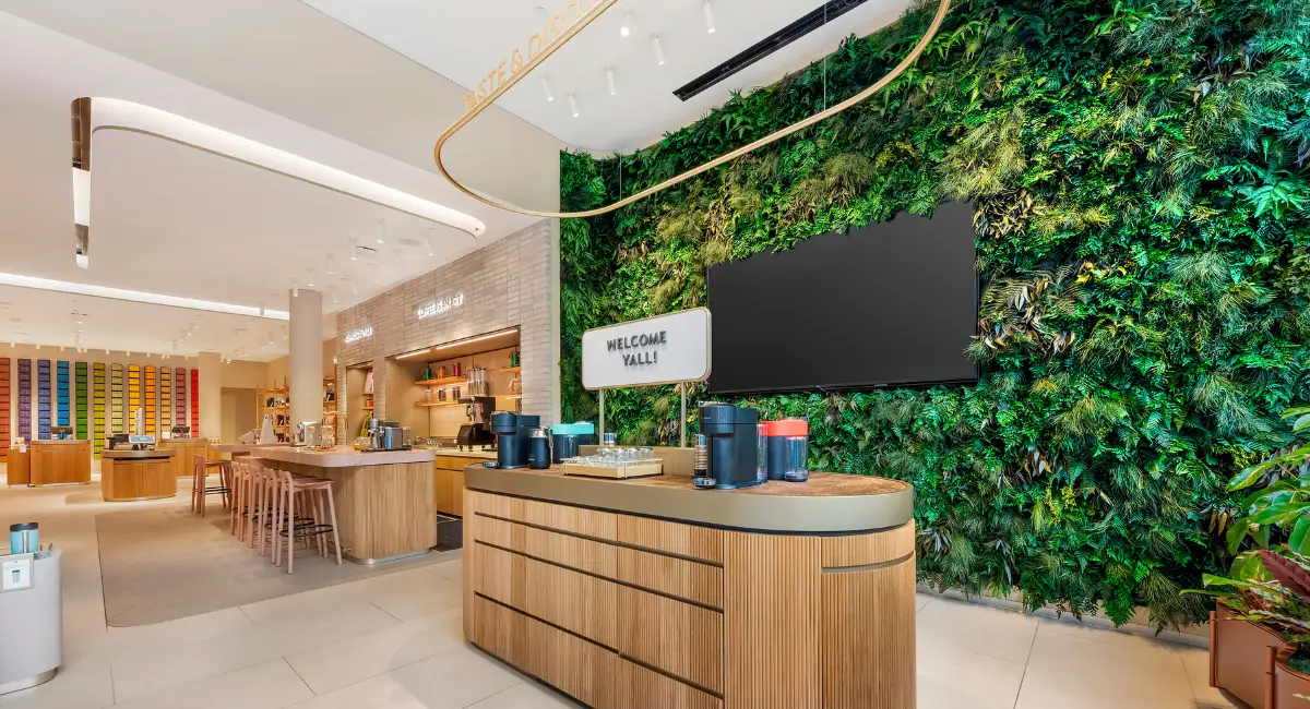 A hybrid green wall in a cafe surrounded by wooden elements creating a biophilic oasis.