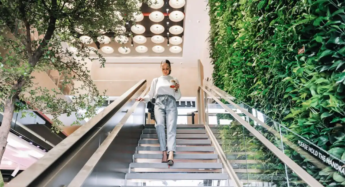 A woman walking downstairs next to a green wall